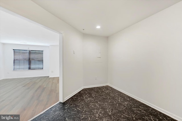 spare room featuring recessed lighting and baseboards