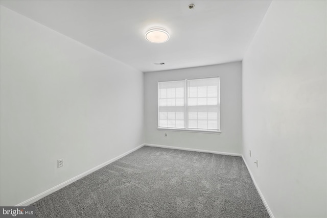carpeted spare room featuring baseboards and visible vents