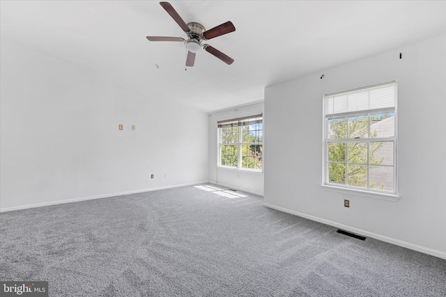 carpeted empty room with baseboards, ceiling fan, and visible vents