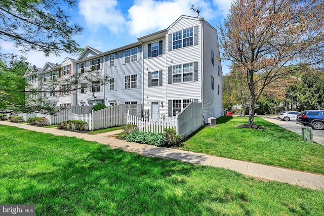 exterior space featuring fence, a lawn, and central AC