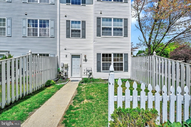 townhome / multi-family property featuring fence and a front yard