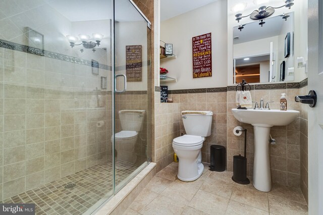 75 NW Dr, Huntingtown, MD 20639 - bathroom with tile walls, a shower stall, toilet, tile patterned floors, and wainscoting