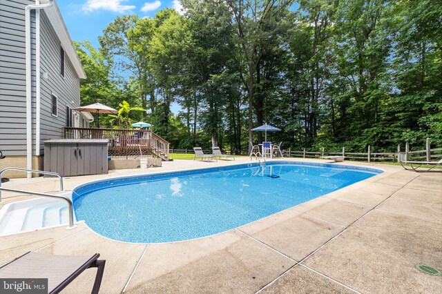 75 NW Dr, Huntingtown, MD 20639 - outdoor pool with a deck, a patio, view of scattered trees, and a diving board