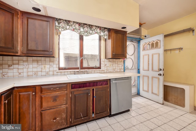 kitchen with light tile patterned flooring, light countertops, tasteful backsplash, a sink, and dishwasher