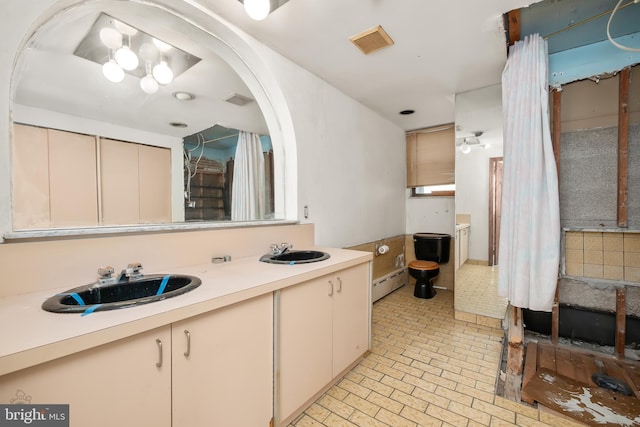 full bath with visible vents, a sink, brick patterned floor, and double vanity