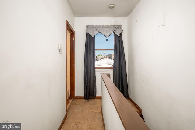 hall with baseboards and an upstairs landing