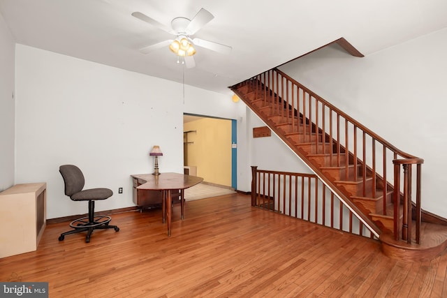 interior space featuring ceiling fan, baseboards, and hardwood / wood-style flooring