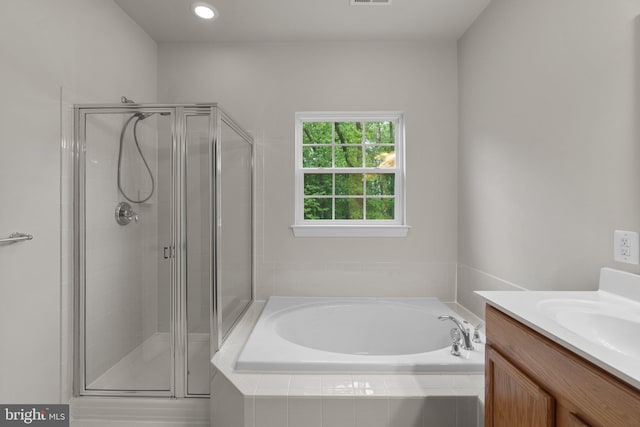 full bath featuring a stall shower, a garden tub, and vanity