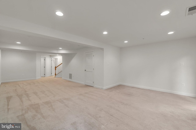 finished basement featuring recessed lighting, light colored carpet, baseboards, and stairs