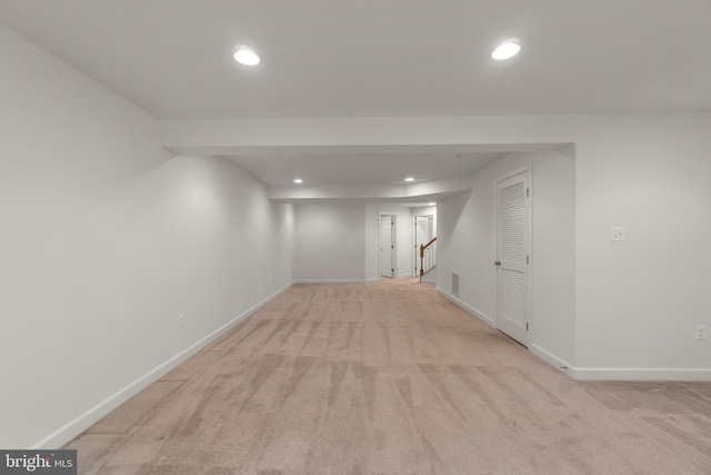 finished below grade area with light colored carpet, recessed lighting, baseboards, and stairway