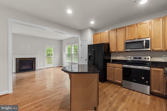 kitchen with stainless steel appliances, light wood finished floors, open floor plan, a center island, and recessed lighting