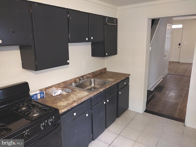 615 Lake St, Lancaster, PA 17603 - kitchen featuring dark cabinetry, light tile patterned floors, a sink, and black range with gas stovetop