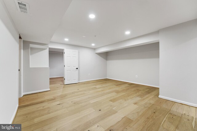finished below grade area featuring baseboards, recessed lighting, light wood-style flooring, and visible vents