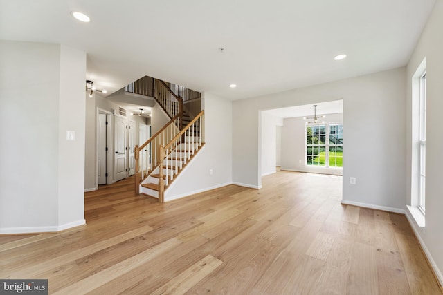 interior space with stairs, baseboards, recessed lighting, light wood finished floors, and a notable chandelier