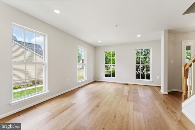 unfurnished living room with visible vents, stairs, baseboards, light wood finished floors, and recessed lighting