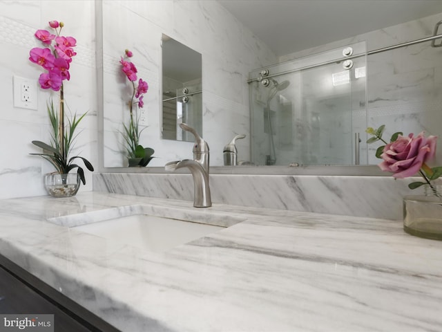 bathroom with vanity and a shower with door