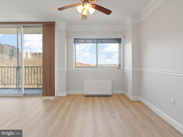 spare room with crown molding, baseboards, a ceiling fan, and wood finished floors