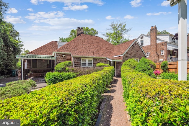 5506 39th Ave, Hyattsville, MD 20781 - view of front of property with brick siding, fence, a shingled roof, and a chimney