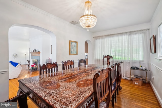5506 39th Ave, Hyattsville, MD 20781 - dining area with arched walkways, wood finished floors, a chandelier, ornamental molding, and baseboards