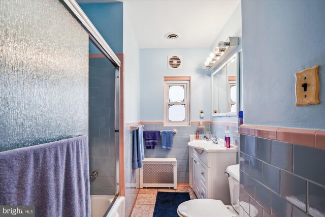 5506 39th Ave, Hyattsville, MD 20781 - full bathroom with radiator, tile walls, vanity, bath / shower combo with glass door, and toilet