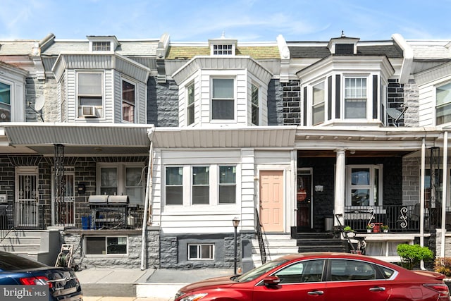 view of property with entry steps, cooling unit, and stone siding