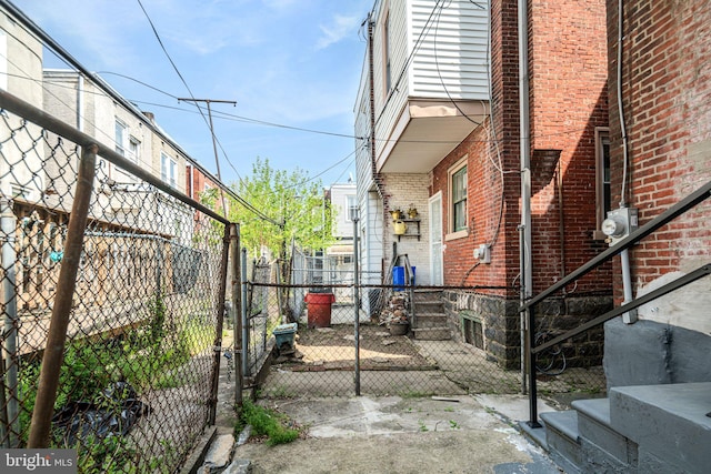 view of side of property with a gate, fence private yard, and brick siding