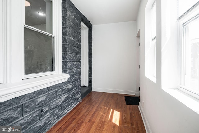 unfurnished room with baseboards and wood finished floors