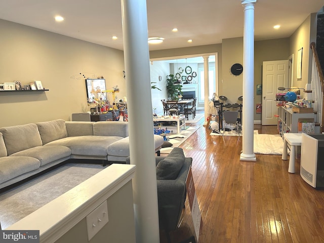 living area featuring ornate columns, recessed lighting, and hardwood / wood-style flooring