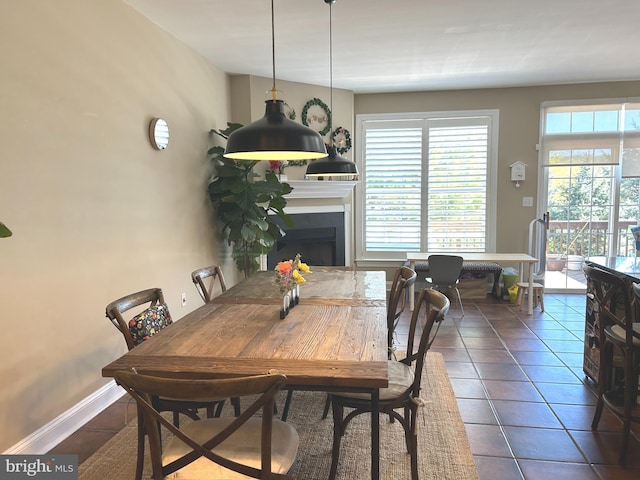 dining area featuring tile patterned flooring, a fireplace, and a wealth of natural light