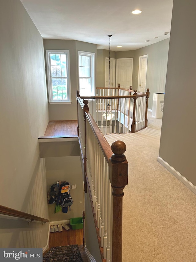 stairway with baseboards and carpet flooring