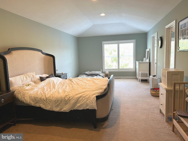 bedroom with carpet floors and lofted ceiling