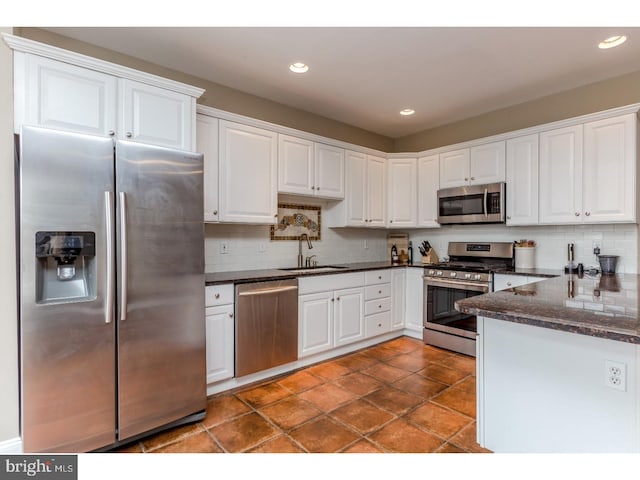 kitchen with a sink, appliances with stainless steel finishes, and white cabinets