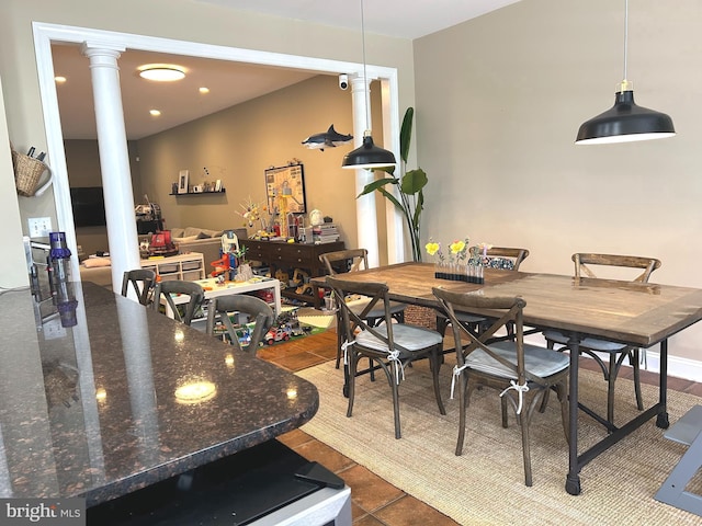 dining area with dark tile patterned flooring, decorative columns, and recessed lighting