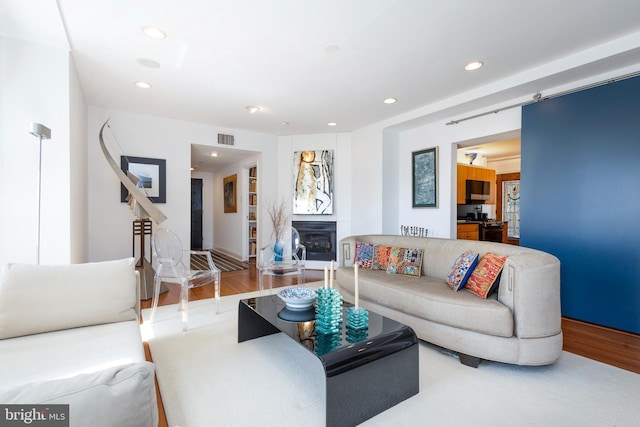 living room featuring visible vents, recessed lighting, wood finished floors, and a fireplace