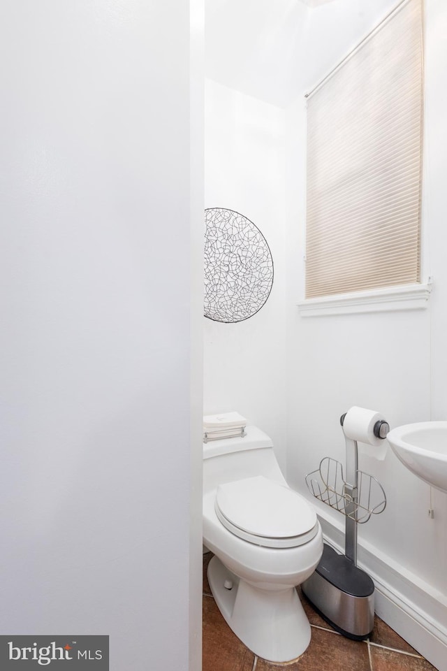 half bathroom with tile patterned floors and toilet