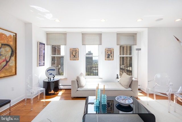 living room featuring recessed lighting, baseboards, a baseboard heating unit, and wood finished floors