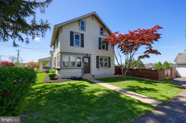 view of front of house with a front yard, fence, and entry steps