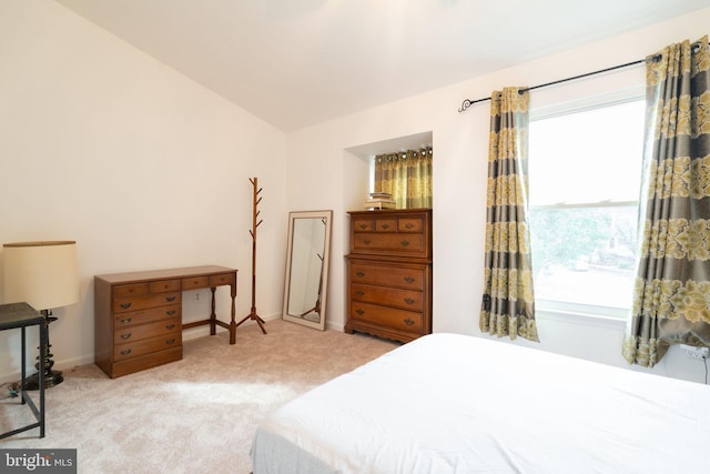 carpeted bedroom with vaulted ceiling and baseboards