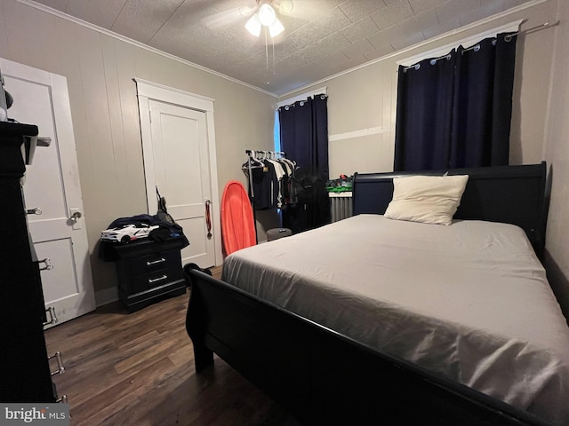 bedroom with crown molding and wood finished floors