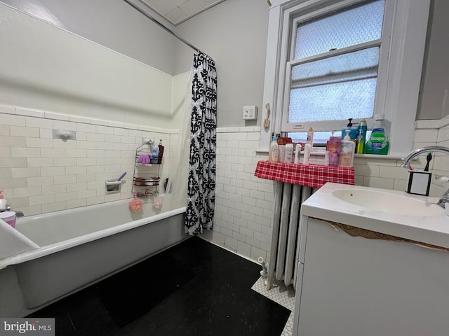 bathroom with tile walls, vanity, and wainscoting