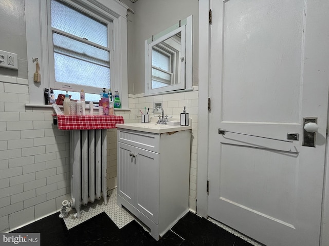 bathroom with tile walls, wainscoting, and vanity