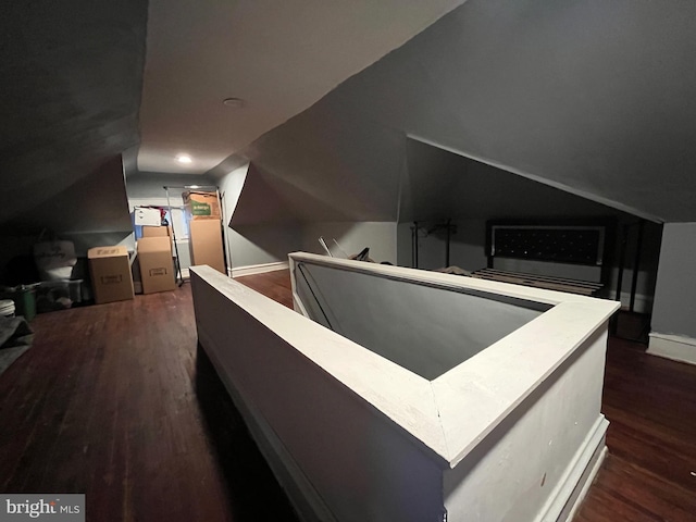 interior space featuring lofted ceiling, baseboards, and wood finished floors