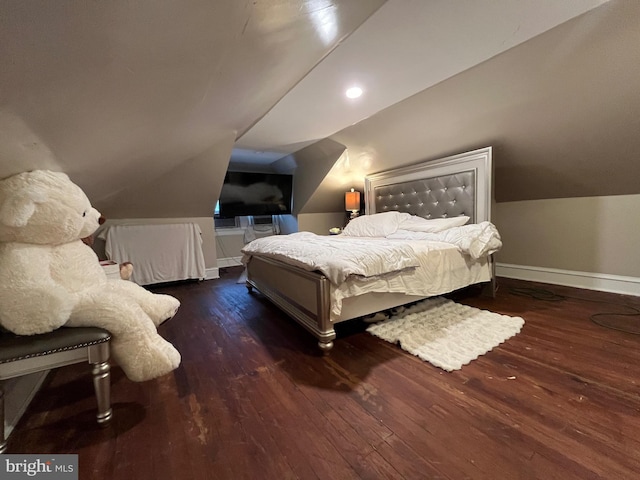 bedroom with vaulted ceiling, wood-type flooring, and baseboards