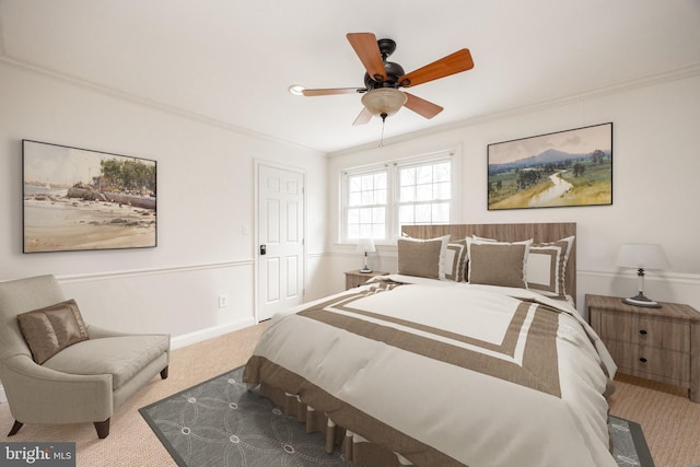 carpeted bedroom featuring baseboards, ornamental molding, and a ceiling fan