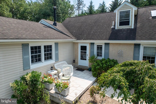 exterior space with a patio and a shingled roof