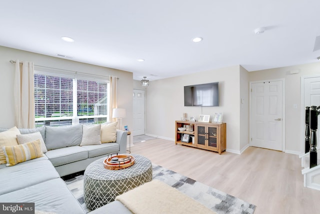 living room with light wood-style floors, baseboards, recessed lighting, and visible vents