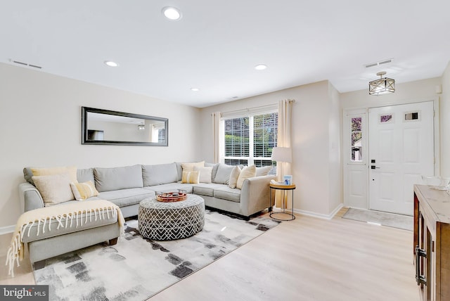 living room with recessed lighting, baseboards, light wood finished floors, and visible vents