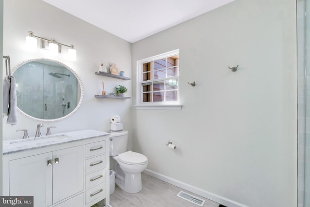 bathroom with visible vents, vanity, toilet, baseboards, and a stall shower