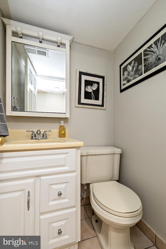 half bath featuring tile patterned flooring, toilet, and vanity