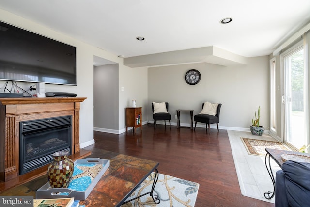 living room featuring recessed lighting, baseboards, a glass covered fireplace, and wood finished floors